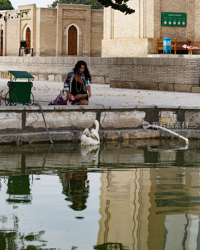 在乌兹别克斯坦的Chor Bakar，一位女士坐在湖边